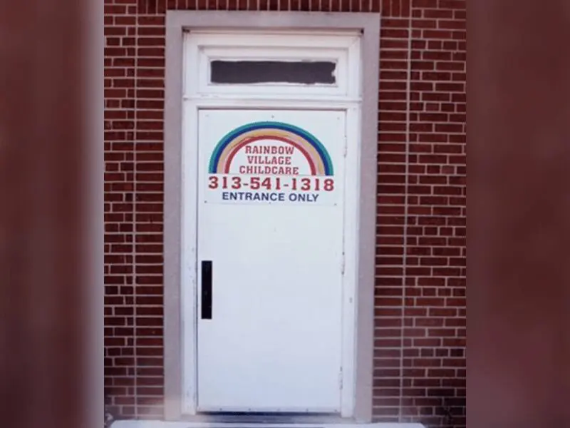 A door with the rainbow on it and a brick wall.