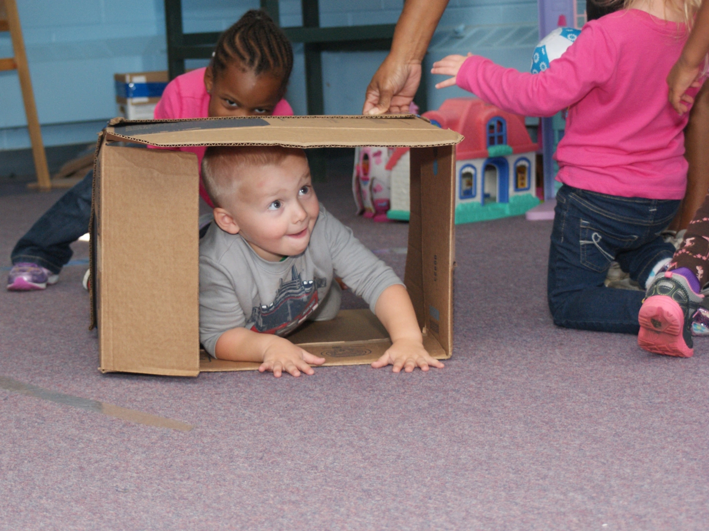 A young child is playing in a box